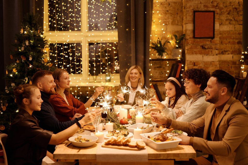 A scene of a family and guest gathered around a table, enjoying Christmas dinner